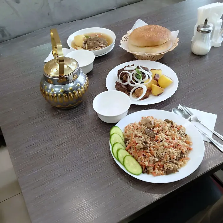 Плов с говядиной, шурпа в пиале и мясо с картофелем и луком